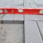 precision leveling of interlock pavers during walkway installation